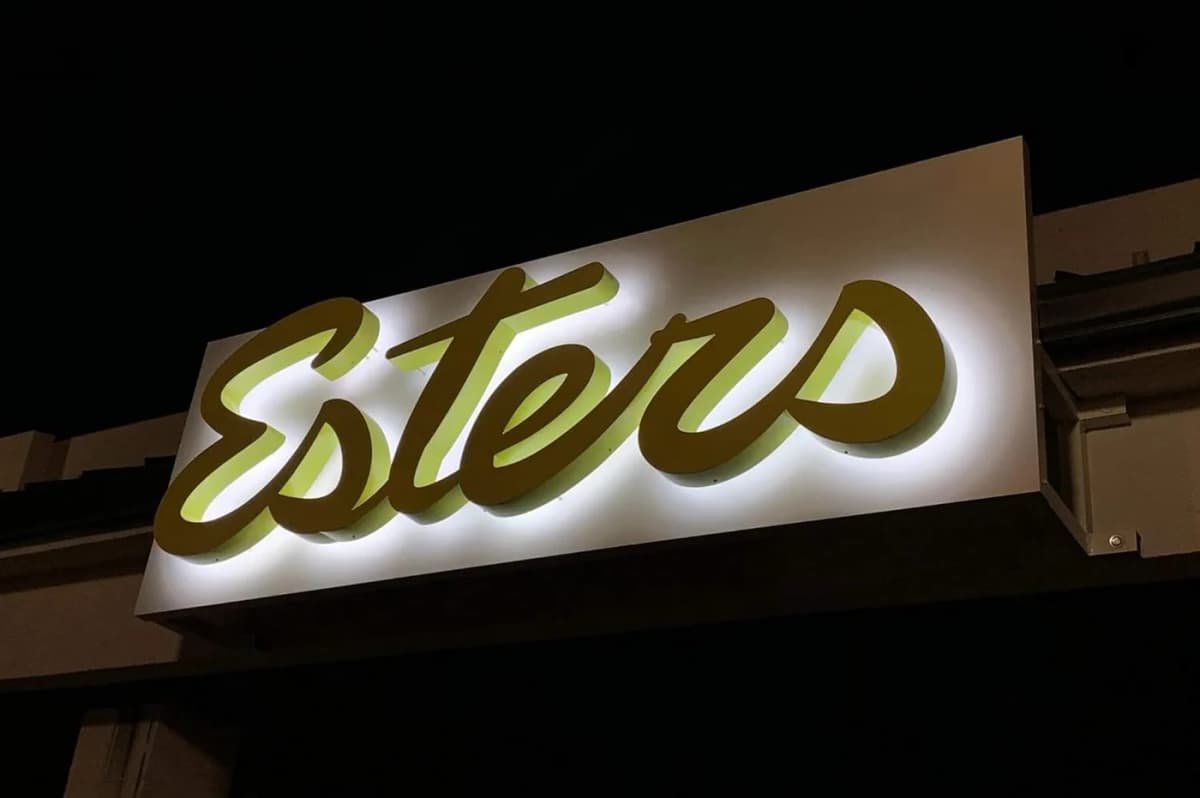 Illuminated retail storefront fascia signage at night