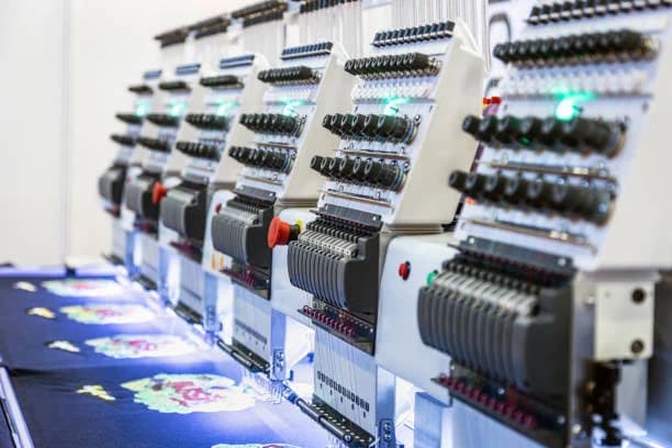 Industrial embroidery machines stitching corporate logos on uniforms